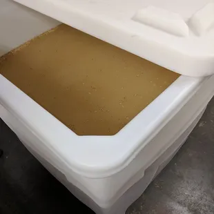 a white container with a brown liquid in it