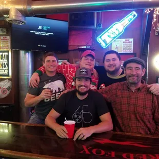 a group of men sitting at a bar