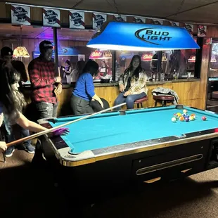 a group of people playing pool