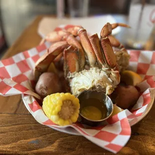 crab legs, potatoes, corn, and mustard