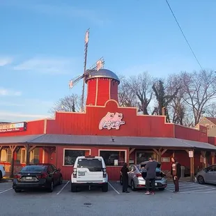 a restaurant with cars parked in front of it