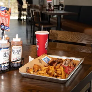 a tray of fries and a drink on a table