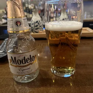 a glass of beer and a bottle of modelo
