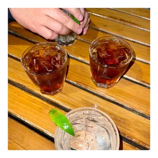 two glasses of ice tea and a glass of soda