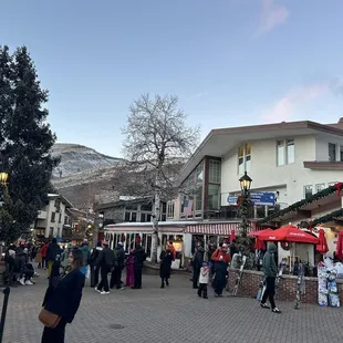 a crowd of people walking around a town square