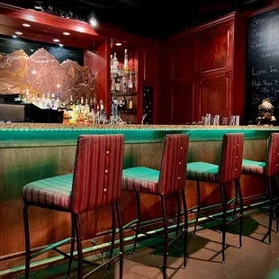 a bar with green bar stools