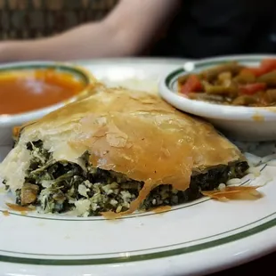 Spinach pie served with a side of rice pilaf and veggies