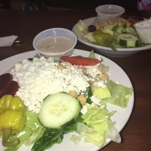 a plate of salad and a bowl of dressing
