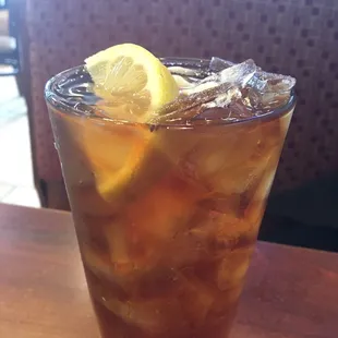 a glass of iced tea with a lemon wedge