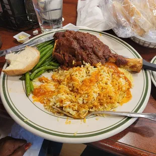 Delicious lamb shank with rice and red sauce and garlic beans. Beans tasted like they were cooked in plain water with no seasoning.