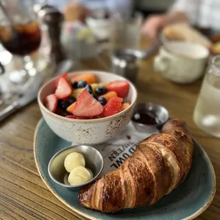 a croissant and fruit salad