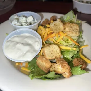 a white plate with a salad and dressing