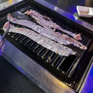 bacon being cooked on a grill
