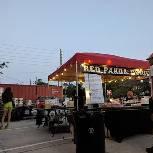 a man standing in front of a food stand