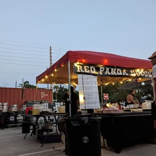 a man standing in front of a food stand