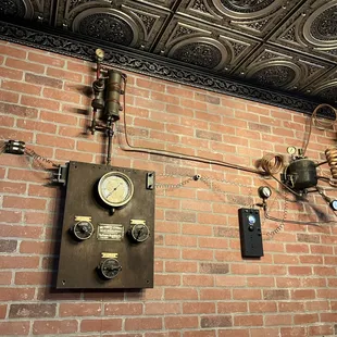 a brick wall with a clock and a wall mounted telephone