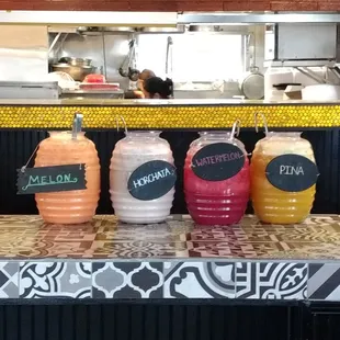 a row of juices on a counter
