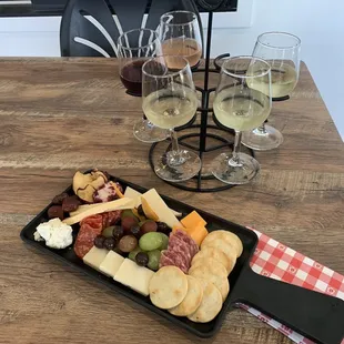 a platter of charcutette, cheese, grapes, and crackers