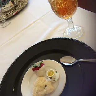 Pre entree scone with a tiny tea cup of lemon sauce and a white chocolate dipped strawberry....on the house.