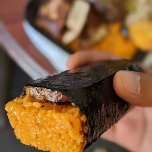 a hand holding a piece of food