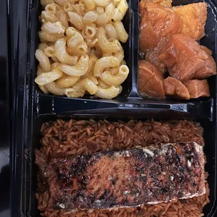 Salmon over a bed of red rice, yams, Mac &amp; cheese.