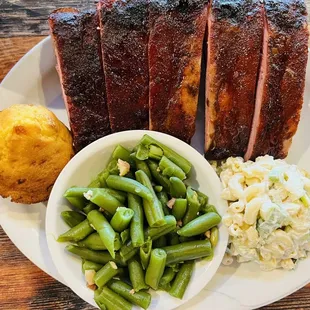 a plate of ribs, green beans, and potato salad