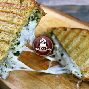 a hand holding a grilled cheese sandwich