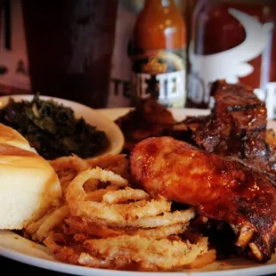 a plate of food with meat, fries, and greens