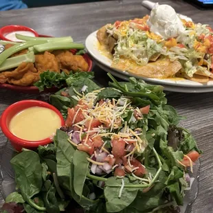 Fresh salad with happy hour wings and nachos