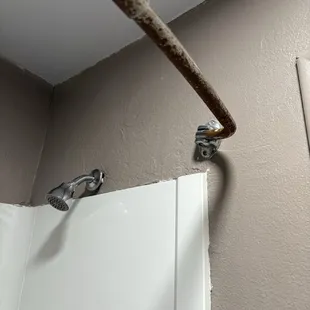 Rusted shower curtain, paint actively chipping off the walls.