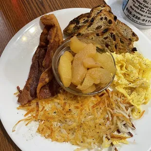 Hashbrowns, eggs, apples, bacon, raisin toast