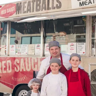 a family standing in front of a food truck