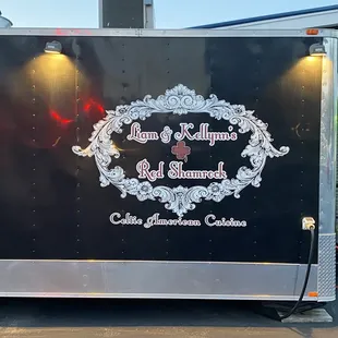 a black food truck with a red bow