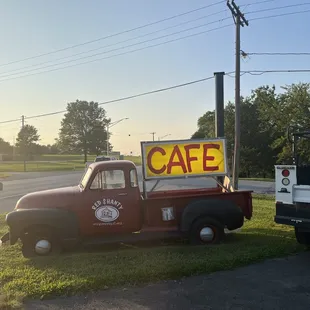 an old truck with a cafe sign