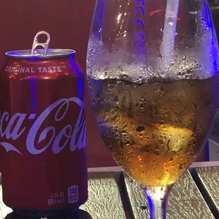 a glass of coke and a can of coke