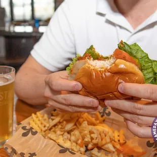 a man holding a sandwich and fries