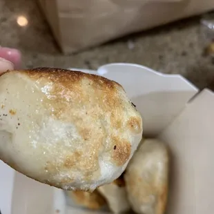 a hand holding a piece of bread