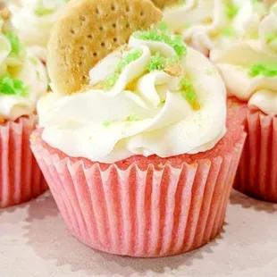 cupcakes with white frosting and green sprinkles