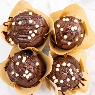 Triple Chocolate Cupcake: Chocolate cupcake with chocolate ganache layer topped with chocolate buttercream and white chocolate sprinkles.