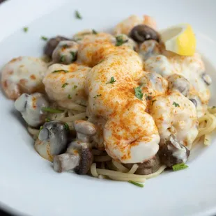 a plate of pasta with shrimp and mushrooms