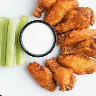 a plate of chicken wings and celery