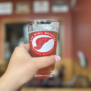 a hand holding a glass of beer