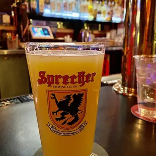 a glass of beer sitting on a bar