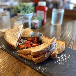 a grilled sandwich on a slate board