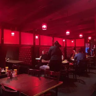 people sitting at tables in a dimly lit restaurant
