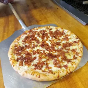 a pizza with bacon and cheese