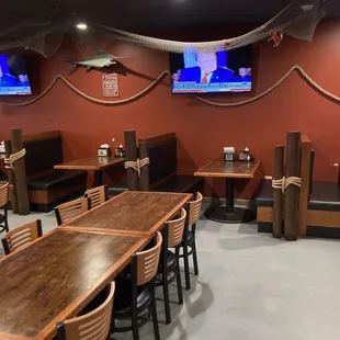 a restaurant with tables, chairs, and televisions