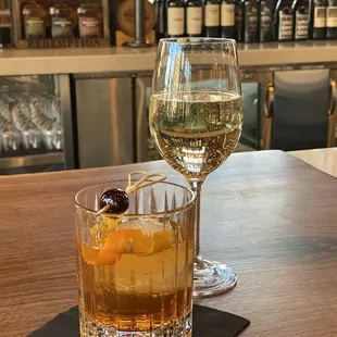 a glass of wine and a drink on a bar