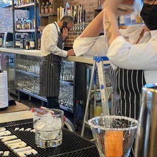 a bartender pouring a drink at the bar