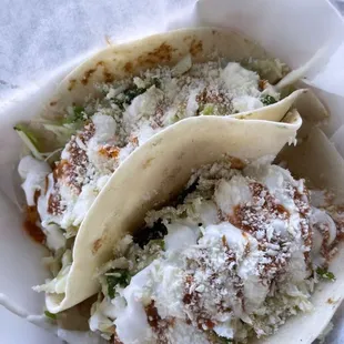 two tacos in a paper container